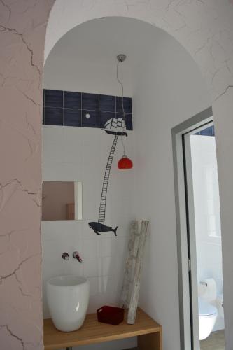 a bathroom with a white sink and a ladder on the wall at Casa Polly B&B in Grottammare