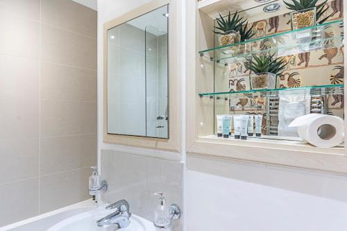 a bathroom with a sink and a mirror at Canary Wharf - Luxury Apartments in London