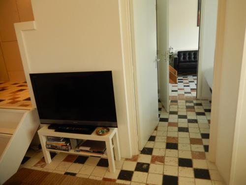 a living room with a tv and a checkered floor at Apartment Amsterdam New West - Free parking in Amsterdam