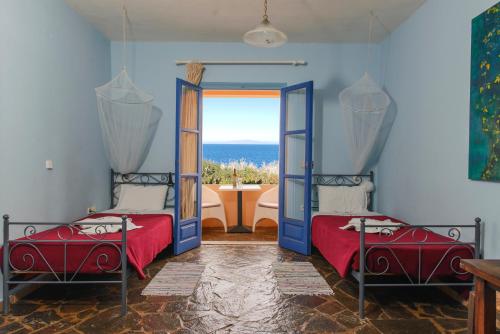 two beds in a room with a view of the ocean at Ocea Retreat in Karlovasi