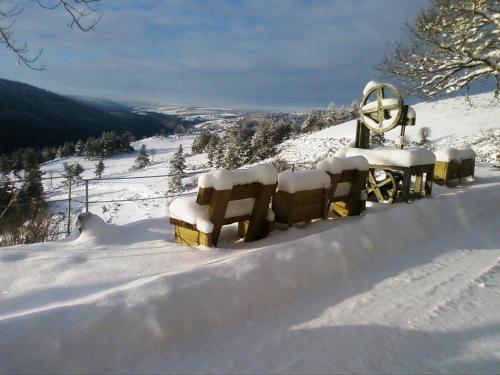 a snow covered hillside with a snow covered telescope at La Bergerie du Plateau in Cros-de-Géorand