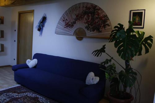a blue couch in a living room with a plant at Appartamento Al Castello in Levico Terme