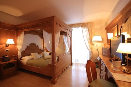 a bedroom with a canopy bed in a room at Dolce Avita Hotel Spa & Resort in Andalo