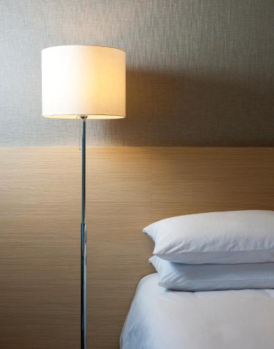 a lamp sitting next to a bed in a bedroom at Hotel Regent Marine The Blue in Jeju