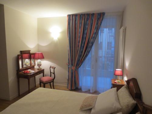 a bedroom with a bed and a desk and a window at Casa Panvinio in Verona