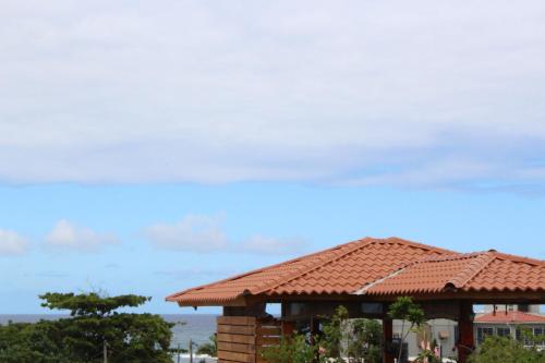 a building with a tiled roof in front of the ocean at Elisa Furnished Apartments (Puerto Plata City) in San Felipe de Puerto Plata