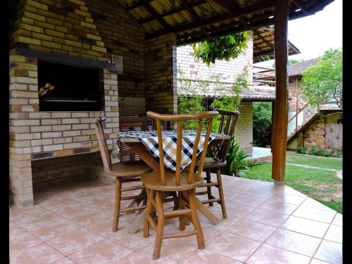 eine Terrasse mit 2 Stühlen und einem Tisch mit Kamin in der Unterkunft Pousada Morada Flor da Terra in Guarda do Embaú