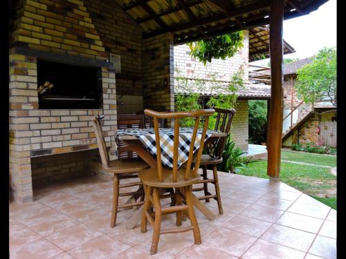un patio con 2 sillas y una mesa con chimenea en Pousada Morada Flor da Terra, en Guarda do Embaú