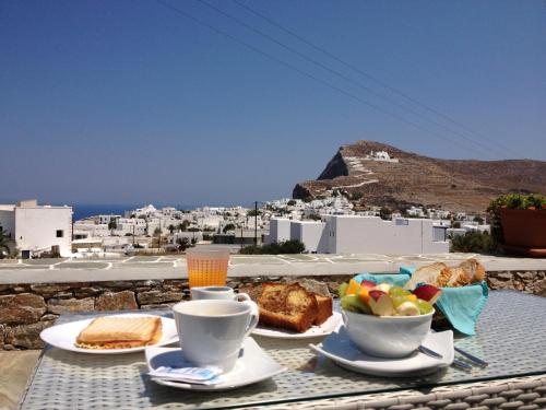 un tavolo con cibo e un cesto di frutta sopra di Horizon Hotel a Chora Folegandros