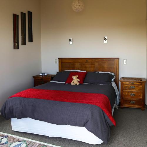 a bedroom with a bed with a teddy bear on it at Lingalonga in Charleston