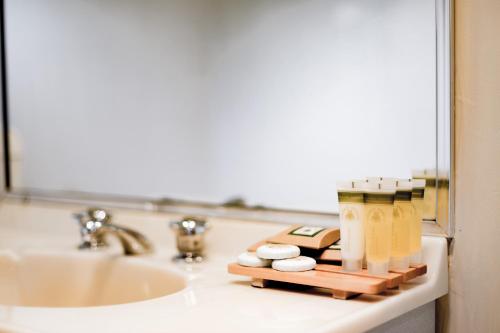 a bathroom sink with a tray of soap and pills at Bundanoon Country Inn Motel in Bundanoon