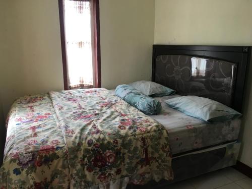 ブロモ山にあるBromo Deddy Homestayのベッドルーム1室(ベッド1台、キルト、枕付)