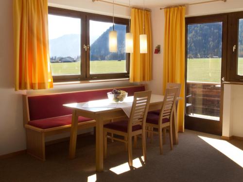 een eetkamer met een tafel en stoelen en een raam bij Haus Karoline in Achenkirch
