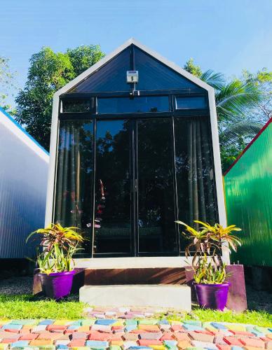 a glass house with two potted plants in front of it at Lanzones Cabana in Mambajao