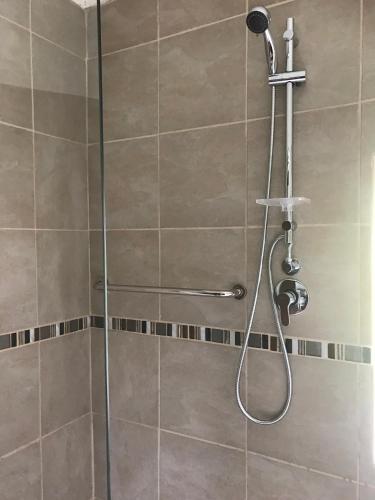 a shower with a shower head in a bathroom at Kromrivier Farm Stays & B&B Near Addo Elephant Park in Paterson
