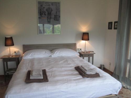 a bedroom with a large white bed with two tables at Casa Balducci Bed&Breakfast in Mercatello sul Metauro