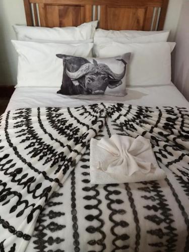 a black and white blanket on a bed with a bull skull on it at Kromrivier Farm Stays & B&B Near Addo Elephant Park in Paterson