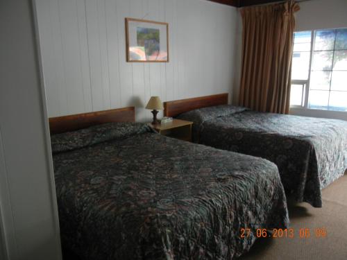 Postel nebo postele na pokoji v ubytování Holiday House Motel