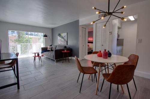 a living room with a table and chairs and a couch at 23 Palms Suites - Midtown Wynwood in Miami
