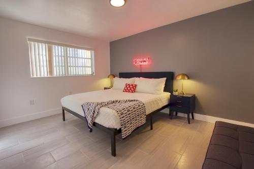 Schlafzimmer mit einem Bett, einem Tisch und einem Fenster in der Unterkunft 23 Palms Suites - Midtown Wynwood in Miami