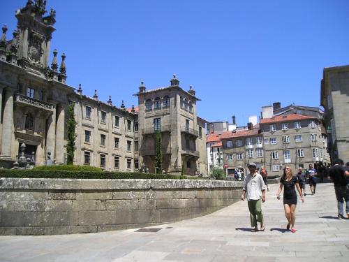 a man and woman walking down a city street at Apartamentos Casa de La Inmaculada in Santiago de Compostela