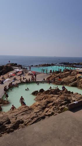 a group of people swimming in pools on a beach at Porto Sea Apartments in Matosinhos