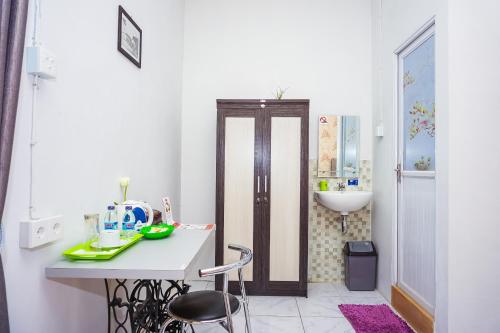 a white bathroom with a sink and a table and chairs at OYO 433 Nelvi Guest House Syariah in Padang
