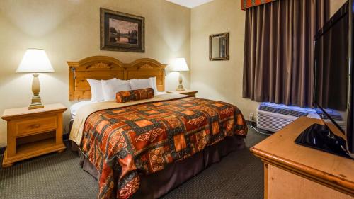 Habitación de hotel con cama y TV de pantalla plana. en Best Western PLUS Revere Inn & Suites en Paradise