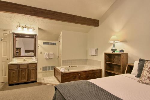 Schlafzimmer mit einem Bett, einer Badewanne und einem Waschbecken in der Unterkunft 209 Pointes North Inn in Charlevoix