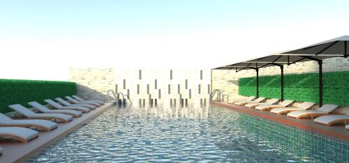einen Pool mit Liegestühlen und einem Pool in der Unterkunft Elegant Airport Hotel in Bangkok