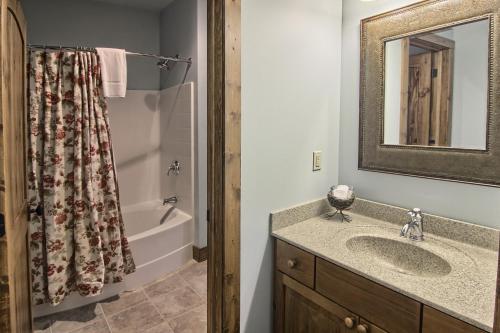 ein Badezimmer mit einem Waschbecken, einem Spiegel und einer Badewanne in der Unterkunft 7317 Creekside Condo in Boyne Falls