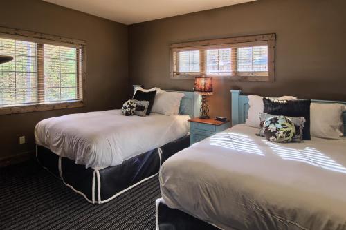 2 Betten in einem Zimmer mit 2 Fenstern in der Unterkunft 7317 Creekside Condo in Boyne Falls