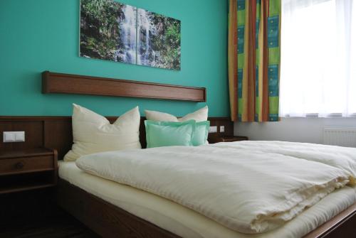 ein Schlafzimmer mit einem großen weißen Bett mit blauen Wänden in der Unterkunft Frühstückspension Paradiesgartl in Amstetten