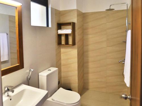 La salle de bains est pourvue de toilettes, d'un lavabo et d'une douche. dans l'établissement Lily's resort, à Habarana