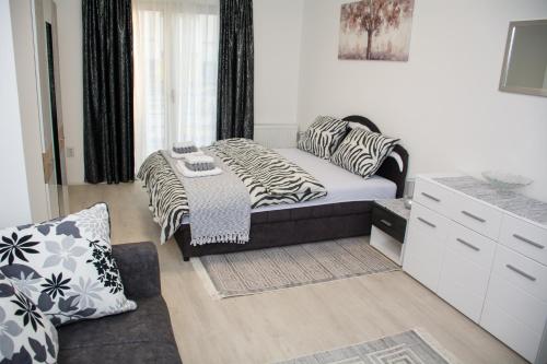 a bedroom with a bed and a couch in a room at Apartment ALEKSANDAR Valjevo in Valjevo