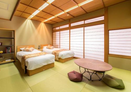 um quarto com duas camas e uma mesa em Juhachiro em Gifu