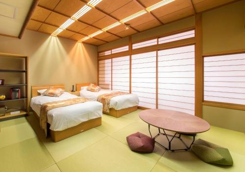 a room with two beds and a table in it at Juhachiro in Gifu