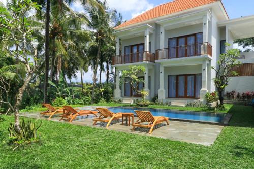 uma villa com piscina e cadeiras e uma casa em Suarsena Villa Ubud em Ubud