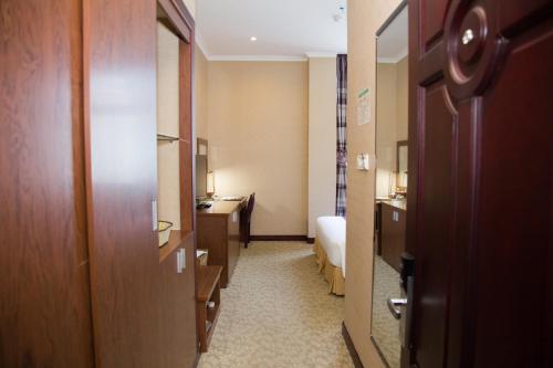 a hallway of a hotel room with a bed and a bathroom at Hai Ba Trung Hotel & Spa in Buon Ma Thuot