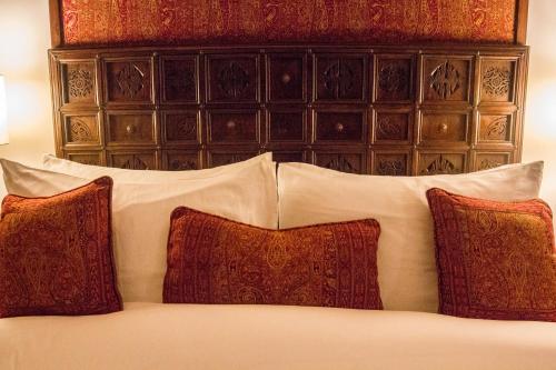 a bed with two pillows and a night stand at Islamabad Serena Hotel in Islamabad