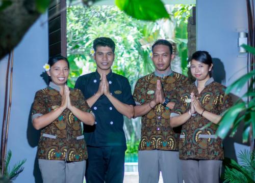 a group of people standing in a group doing yoga at Chimera Villas in Seminyak