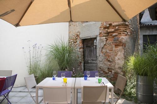 オージオ・ソットにあるAlbergo La Braseriaのパティオ(パラソルの下にテーブルと椅子付)
