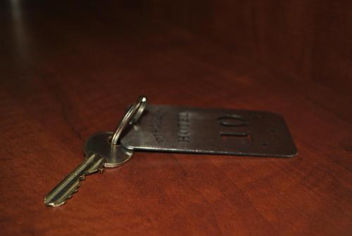 a metal key on top of a wooden table at Discret Hotel & Restaurant in Vladaya
