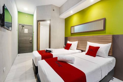 2 łóżka w pokoju z zielonymi i żółtymi ścianami w obiekcie RedDoorz Plus @ Jones Avenue Cebu w Cebu