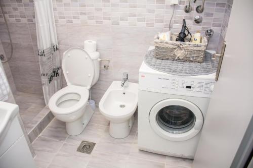 a bathroom with a toilet and a washing machine at Apartment ALEKSANDAR Valjevo in Valjevo