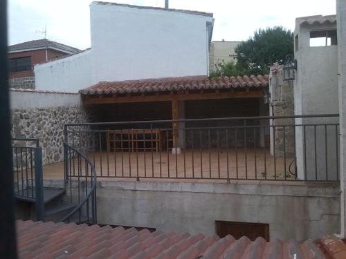einen Balkon eines Gebäudes mit einem Tor und einer Treppe in der Unterkunft La plaza in Villatoro