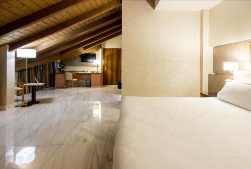 a bedroom with a bed and a living room at Best Western Modena District in Campogalliano