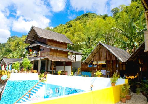 a house with a swimming pool next to a resort at MLK Bamboo Beachhouse in Alegria