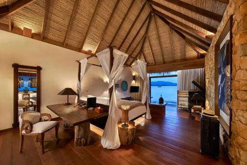 una camera con scrivania e un letto in una stanza di Song Saa Private Island a Isola Privata Song Saa