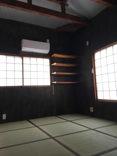 an empty room with two windows and a fan at CRAFT in Matsubara